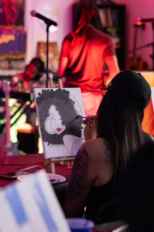 Guest painting a portrait with the band behind her