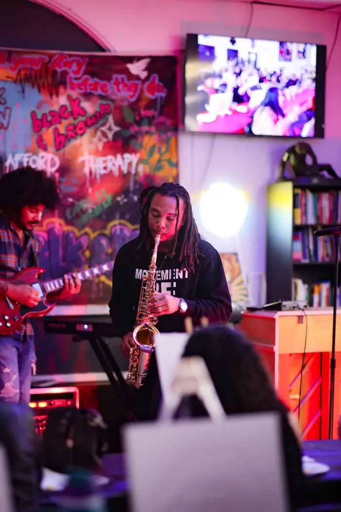 Saxophonist and guitarist on the graffiti-backed stage