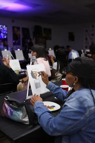 Guests painting under purple light