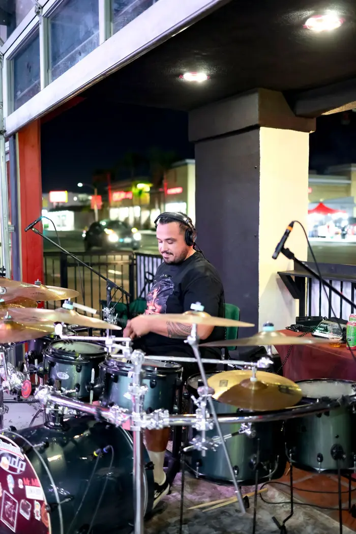 Drummer playing for painters at Mesa Bar